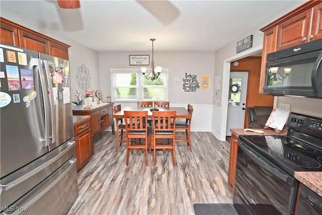 48 Mary Ann Ln, Youngstown, OH 44511 - dining area featuring wood finished floors, a chandelier, a wainscoted wall, and a ceiling fan