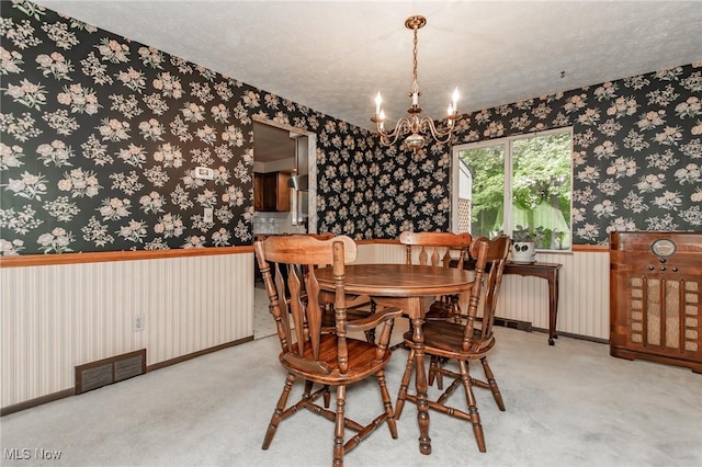 751 Bacon Rd, Oh, OH 44077 - dining area with wallpapered walls, a chandelier, a textured ceiling, and carpet floors