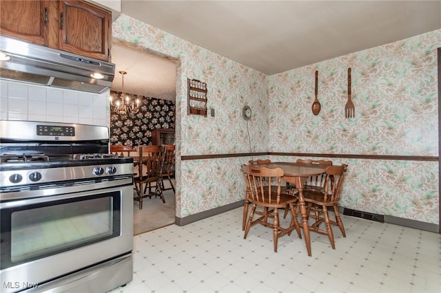 751 Bacon Rd, Oh, OH 44077 - kitchen with gas stove, under cabinet range hood, light floors, wallpapered walls, and a chandelier