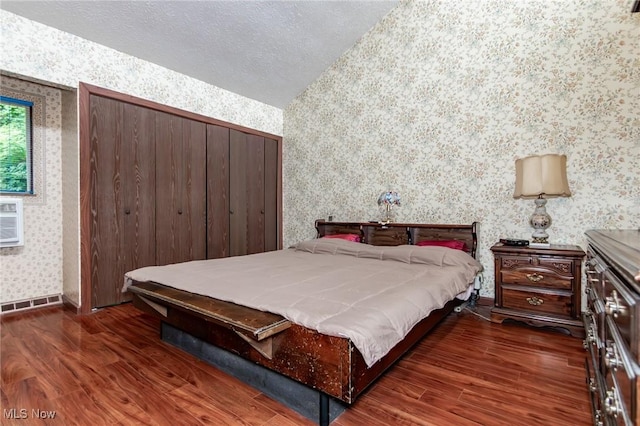 751 Bacon Rd, Oh, OH 44077 - bedroom with wallpapered walls, wood finished floors, vaulted ceiling, a closet, and a textured ceiling