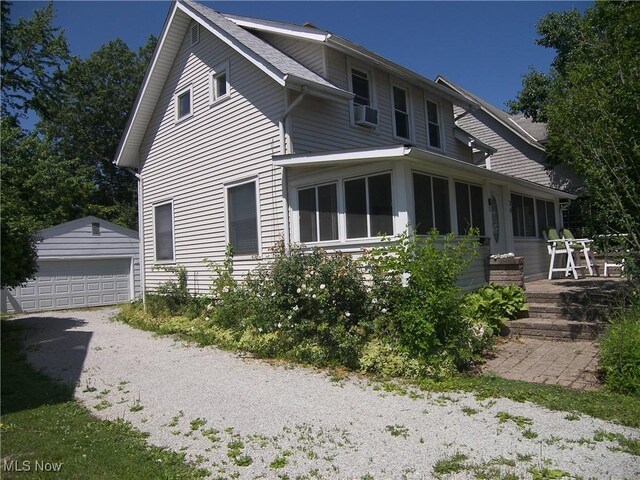 24 E 220th St E, Euclid, OH 44123 - back of house with an outdoor structure, a garage, cooling unit, and roof with shingles