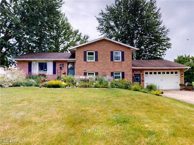 14003 Highview Dr, Dalton, OH 44618 - split level home featuring an attached garage, brick siding, a front lawn, and driveway