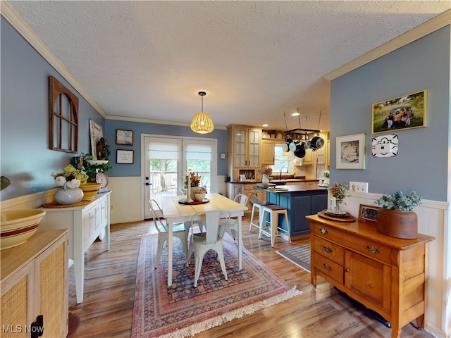 14003 Highview Dr, Dalton, OH 44618 - dining area with ornamental molding, a textured ceiling, a wainscoted wall, and light wood-type flooring
