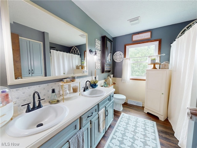 14003 Highview Dr, Dalton, OH 44618 - full bath featuring double vanity, wood finished floors, backsplash, and a shower with curtain