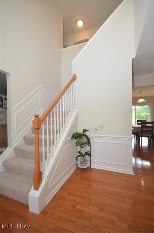 4909 Garnet Cir, Stow, OH 44224 - staircase featuring a decorative wall, wood finished floors, and a wainscoted wall