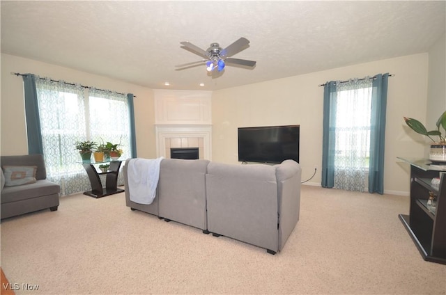 4909 Garnet Cir, Stow, OH 44224 - living room featuring light carpet, a tile fireplace, and a ceiling fan
