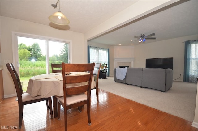 4909 Garnet Cir, Stow, OH 44224 - dining space with light wood-style floors, a fireplace, and a ceiling fan
