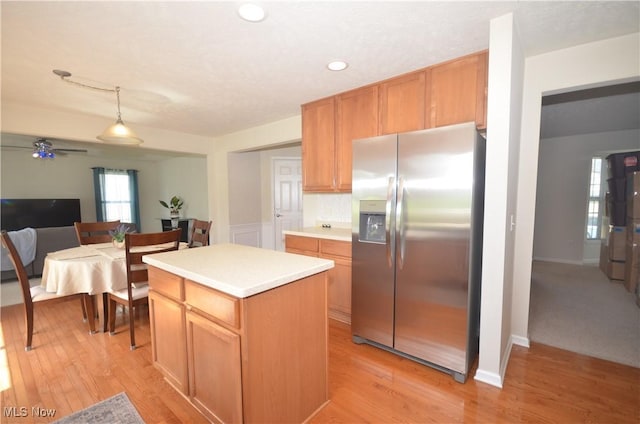 4909 Garnet Cir, Stow, OH 44224 - kitchen with stainless steel fridge, a kitchen island, light countertops, light wood finished floors, and recessed lighting
