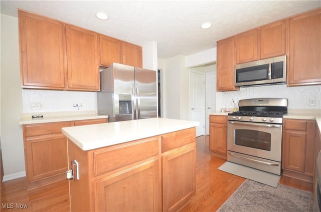 4909 Garnet Cir, Stow, OH 44224 - kitchen with stainless steel appliances, light wood-type flooring, light countertops, recessed lighting, and a center island