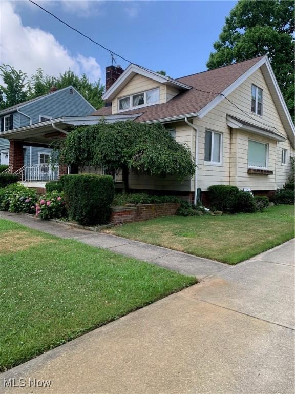1528 Felton Rd, South Euclid, OH 44121 - view of front of home featuring a chimney, a front yard, and roof with shingles