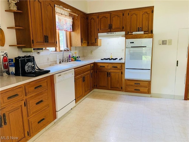 1528 Felton Rd, South Euclid, OH 44121 - kitchen featuring white appliances, a warming drawer, under cabinet range hood, brown cabinets, and tasteful backsplash