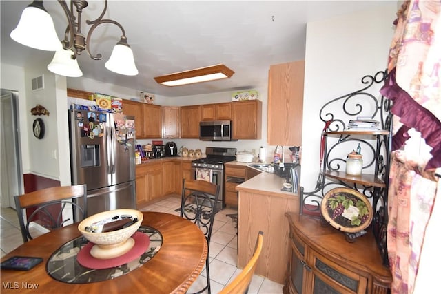 307 Crimson Cir, Campbell, OH 44405 - kitchen featuring stainless steel appliances, light tile patterned flooring, brown cabinets, a chandelier, and light countertops