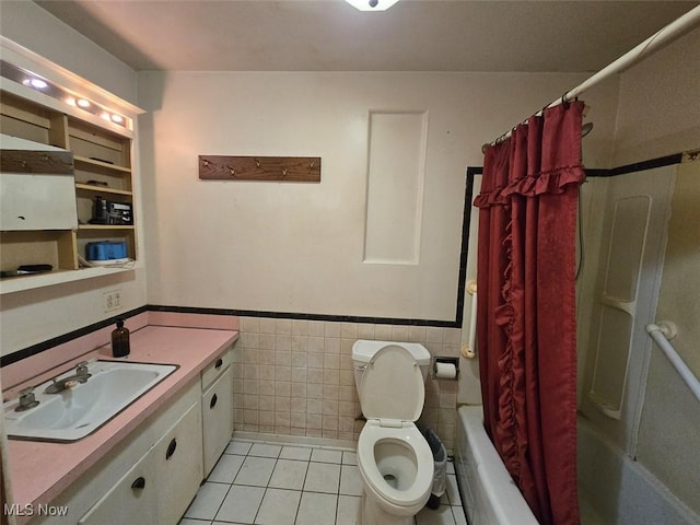 4544 Springvale Ave SW, Canton, OH 44706 - bathroom featuring tile patterned flooring, tile walls, vanity, a wainscoted wall, and shower / tub combo with curtain