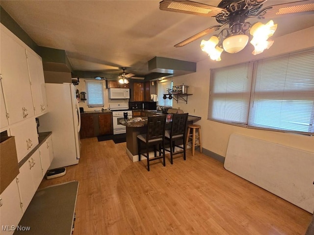 4544 Springvale Ave SW, Canton, OH 44706 - kitchen with white appliances, ceiling fan, dark countertops, a peninsula, and white cabinets