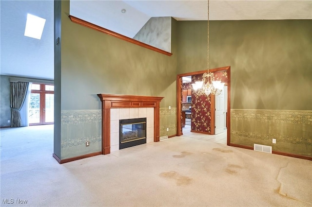 1977 Fox Trace Trl, Cuyahoga Falls, OH 44223 - unfurnished living room featuring high vaulted ceiling, carpet, a chandelier, a fireplace, and wainscoting