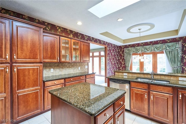 1977 Fox Trace Trl, Cuyahoga Falls, OH 44223 - kitchen with stainless steel dishwasher, wallpapered walls, light tile patterned flooring, a skylight, and dark stone countertops