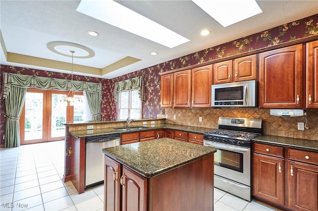 1977 Fox Trace Trl, Cuyahoga Falls, OH 44223 - kitchen featuring stainless steel appliances, a skylight, a peninsula, light tile patterned floors, and wallpapered walls