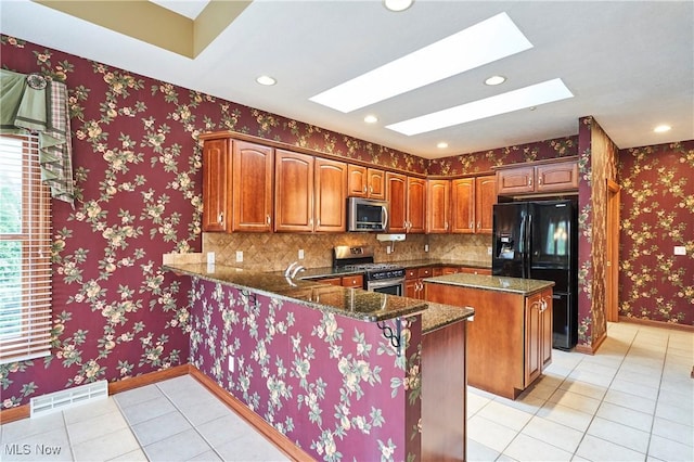 1977 Fox Trace Trl, Cuyahoga Falls, OH 44223 - kitchen with stainless steel appliances, a skylight, light tile patterned flooring, a kitchen island, and healthy amount of natural light