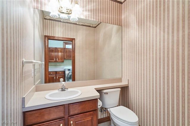 1977 Fox Trace Trl, Cuyahoga Falls, OH 44223 - bathroom featuring washer / dryer, wallpapered walls, vanity, and a chandelier