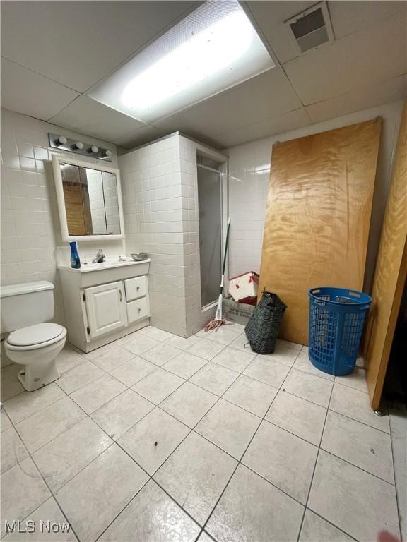 311 Hilda Cir, Bloomingdale, OH 43910 - full bath with vanity, a stall shower, a paneled ceiling, tile patterned floors, and tile walls
