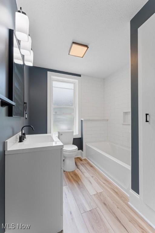 638 High St, Wooster, OH 44691 - full bathroom with vanity, wood finished floors, a tub to relax in, and a textured ceiling