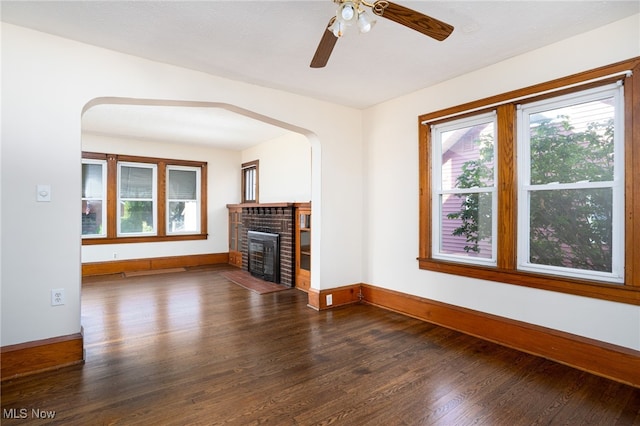 289 E Baird Ave, Barberton, OH 44203 - unfurnished living room with plenty of natural light, dark wood-style floors, a brick fireplace, and ceiling fan