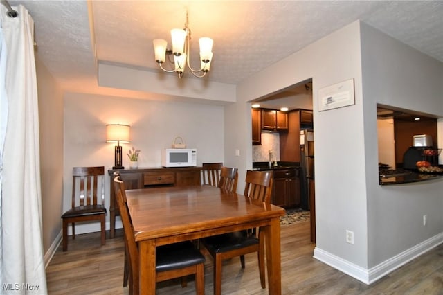 4914 Independence Cir Unit D, Stow, OH 44224 - dining space with a chandelier, wood finished floors, and a textured ceiling