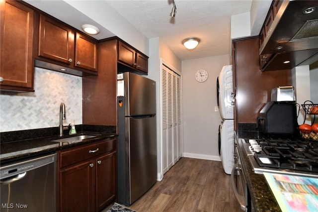 4914 Independence Cir Unit D, Stow, OH 44224 - kitchen with stainless steel appliances, range hood, stacked washing machine and dryer, decorative backsplash, and dark wood-type flooring