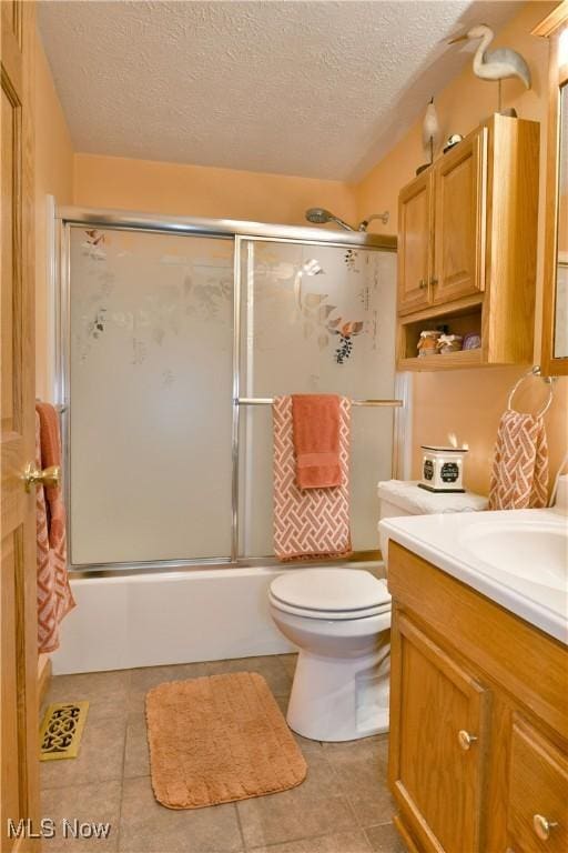 2555 Walnut St, Girard, OH 44420 - bathroom featuring a textured ceiling, vanity, tile patterned flooring, and enclosed tub / shower combo