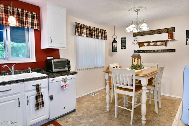 2555 Walnut St, Girard, OH 44420 - kitchen featuring dishwasher, a chandelier, dark countertops, white cabinets, and hanging light fixtures