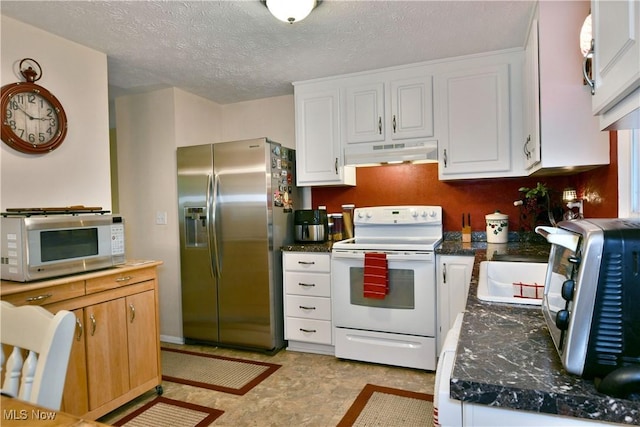 2555 Walnut St, Girard, OH 44420 - kitchen with white appliances, under cabinet range hood, white cabinetry, dark countertops, and a textured ceiling