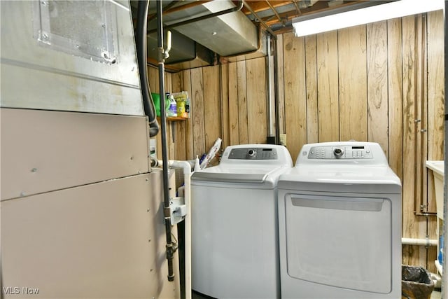 2555 Walnut St, Girard, OH 44420 - laundry room featuring separate washer and dryer, wood walls, and heating unit