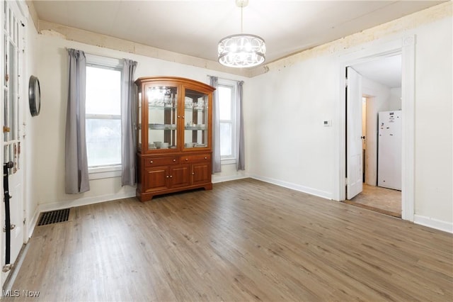 625 W Church St, Orrville, OH 44667 - spare room featuring a chandelier and light wood-style flooring