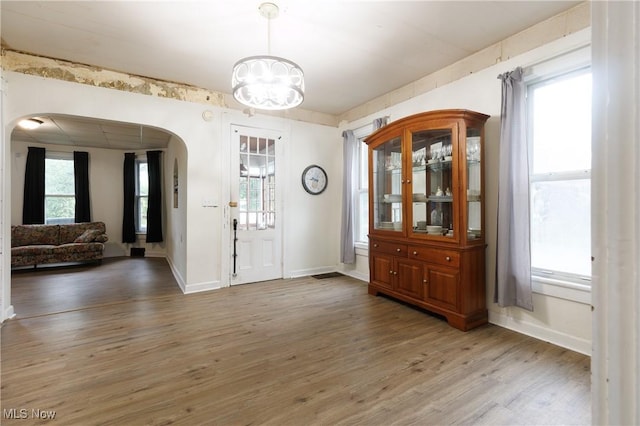 625 W Church St, Orrville, OH 44667 - foyer with arched walkways, light wood-style floors, a chandelier, and plenty of natural light