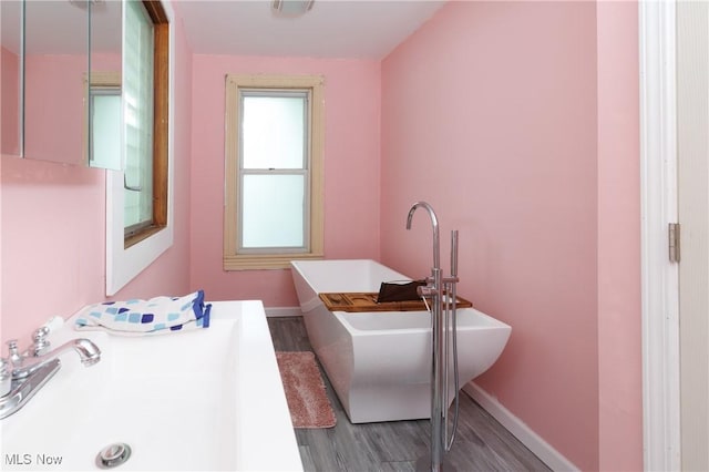 625 W Church St, Orrville, OH 44667 - bathroom featuring wood finished floors and a freestanding tub