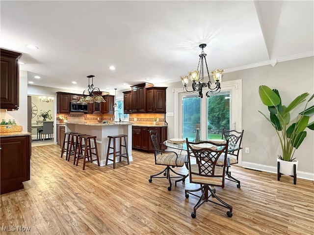 12147 Gladstone Rd SW, North Jackson, OH 44451 - dining room featuring a chandelier, light wood finished floors, crown molding, and recessed lighting