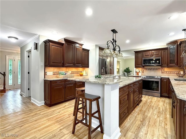 12147 Gladstone Rd SW, North Jackson, OH 44451 - kitchen featuring stainless steel appliances, light wood-style floors, crown molding, tasteful backsplash, and a kitchen island