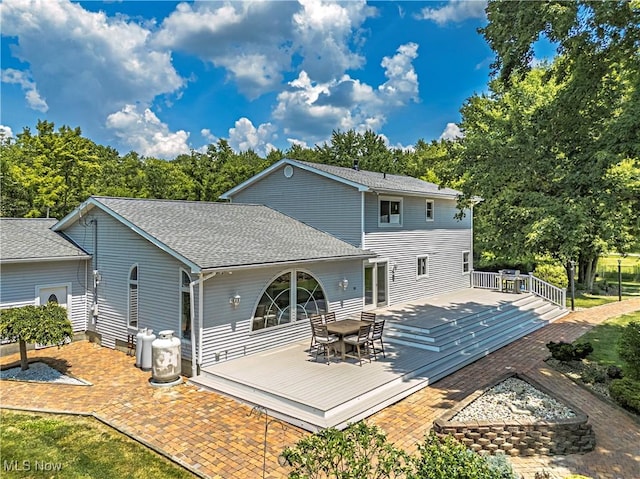12147 Gladstone Rd SW, North Jackson, OH 44451 - rear view of house featuring a wooden deck, roof with shingles, and outdoor dining area