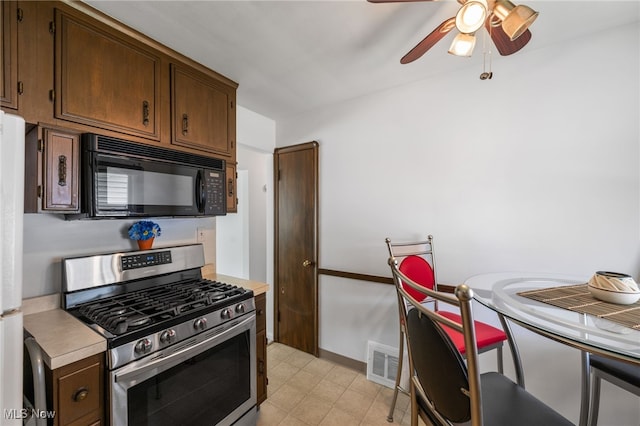 15617 Rockside Rd, Maple Heights, OH 44137 - kitchen with gas stove, black microwave, light countertops, and ceiling fan