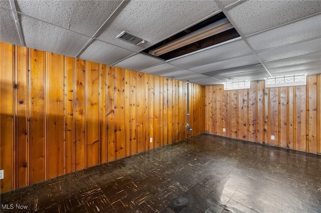 15617 Rockside Rd, Maple Heights, OH 44137 - below grade area with a paneled ceiling, wooden walls, and tile patterned floors