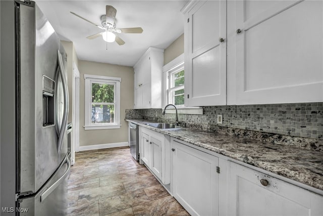 1425 Keefer Rd, Girard, OH 44420 - kitchen with appliances with stainless steel finishes, decorative backsplash, white cabinetry, stone finish floors, and ceiling fan