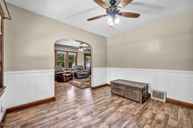 1425 Keefer Rd, Girard, OH 44420 - empty room with arched walkways, ceiling fan, wainscoting, and wood finished floors