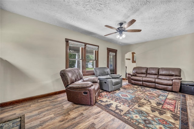 1425 Keefer Rd, Girard, OH 44420 - living room with arched walkways, wood finished floors, a ceiling fan, and a textured ceiling