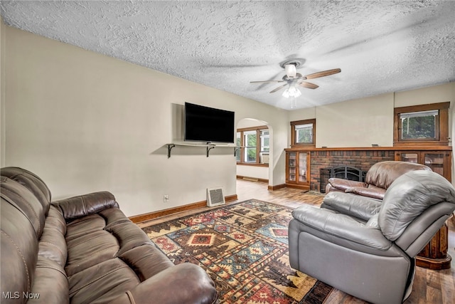 1425 Keefer Rd, Girard, OH 44420 - living area with arched walkways, wood finished floors, a ceiling fan, a textured ceiling, and a fireplace