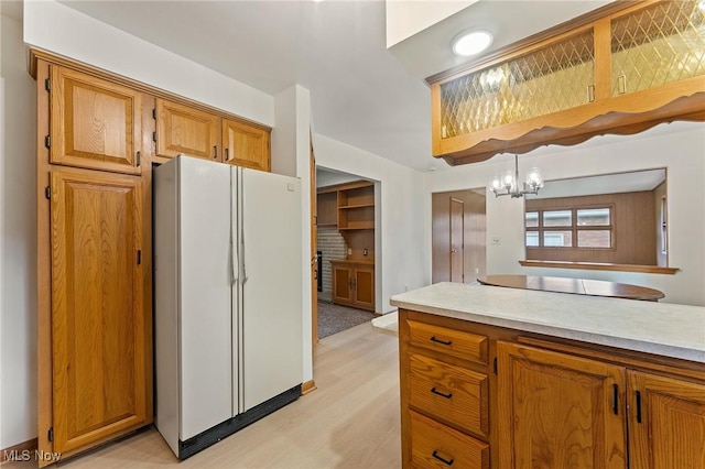 853 Almasy Dr, Campbell, OH 44405 - kitchen with freestanding refrigerator, black electric cooktop, brown cabinets, light wood finished floors, and light countertops