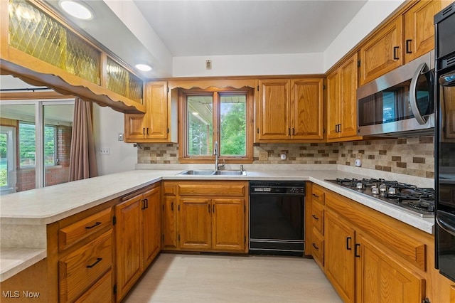 853 Almasy Dr, Campbell, OH 44405 - kitchen with appliances with stainless steel finishes, a peninsula, light countertops, and brown cabinets