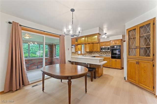 853 Almasy Dr, Campbell, OH 44405 - dining space featuring light wood finished floors and a chandelier