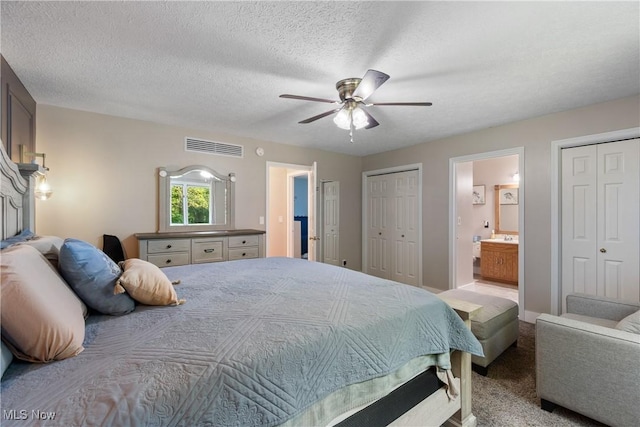 2715 Eastwood Dr, Wooster, OH 44691 - carpeted bedroom featuring two closets, connected bathroom, ceiling fan, and a textured ceiling