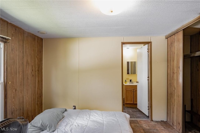 2361 Carpenter Run Rd, Waverly, WV 26184 - bedroom featuring stone finish floors, wooden walls, and connected bathroom