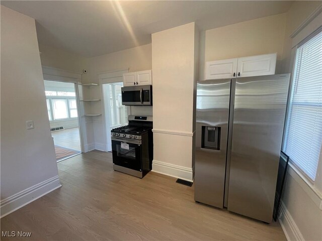 3363 E 125th St, Cleveland, OH 44120 - kitchen with appliances with stainless steel finishes, white cabinetry, and light wood-style flooring